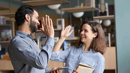 Dos compañeros de trabajo celebran su éxito en administración y finanzas