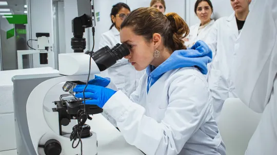 Alumna de anatomía realiza una investigación con un microscopio