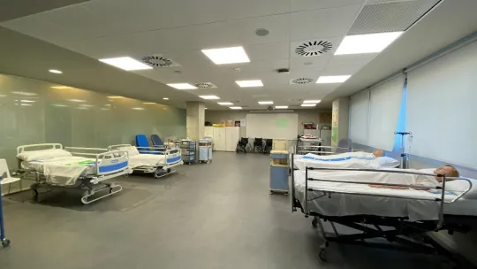 FP Auxiliar de Enfermería en Madrid: nuevo Campus Sanidad iFP Sala de cuidados de enfermeria en un hospital con camas y personas tumbadas