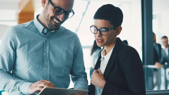 Dos compañeros de Gestión Administrativa en una oficina