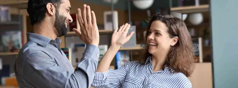 Dos compa帽eros de trabajo celebran su 茅xito en administraci贸n y finanzas