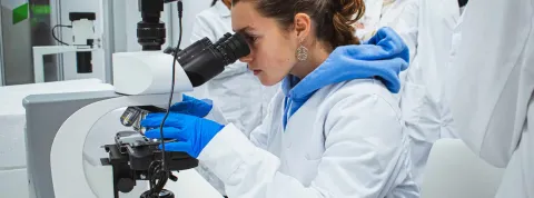 Alumna de anatomía realiza una investigación con un microscopio