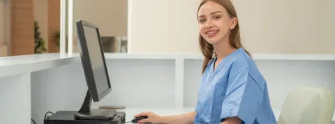 Mujer en su mesa de trabajo, trabaja con ordenador en administración sanitaria