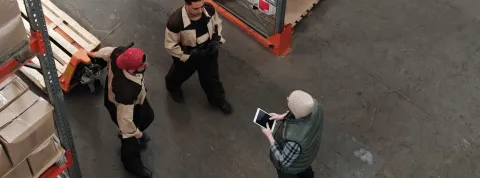 Tres técnicos gestionan la logística en un almacén.