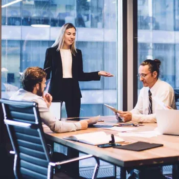Equipo de Administración y Finanzas discute proyecto en una oficina.