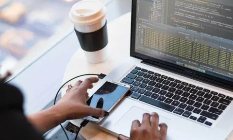 Mujer desarrollando una aplicación multiplataforma en el ordenador