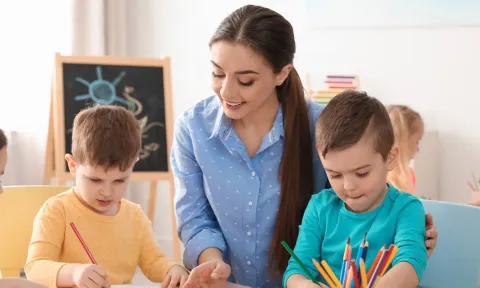 Profesora pintando con sus alumnos escolares en clase