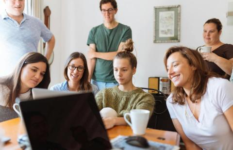 Estudiantes mirando el ordenador de su compañera