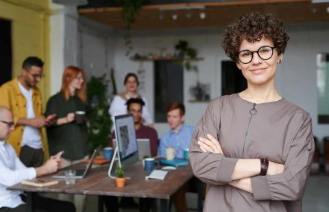 foto de mujer joven con gafas y brazos cruzados en una oficina