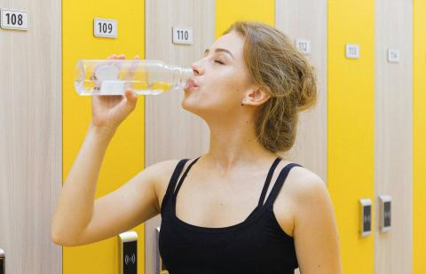 Una chica está bebiendo una botella de agua