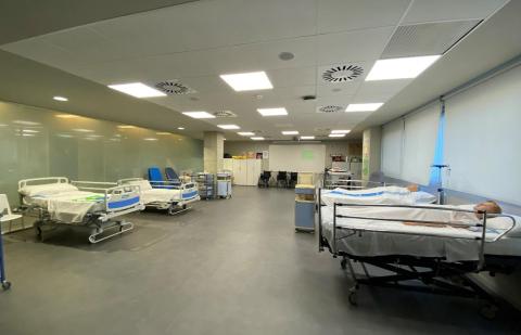 Sala de cuidados de enfermeria en un hospital con camas y personas tumbadas