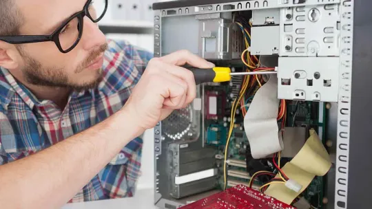 Informático joven trabaja en los componentes de un ordenador.