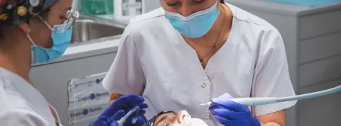 Higienista Bucodental y odontóloga realizan un tratamiento en una clínica dental.