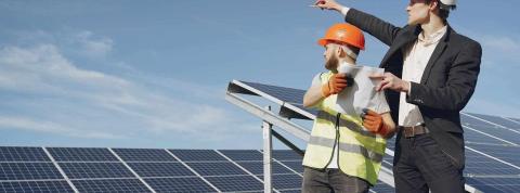 Dos hombres en un campo solar analizan la situación de la instalación de placas solares.