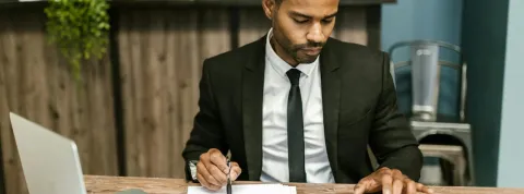 hombre en traje en una oficina haciendo cuentas