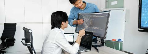 Dos hombres jóvenes aprenden a programar y practican sus habilidades de lógica juntos.