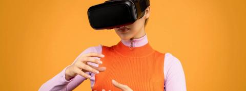 Una mujer con gafas de realidad virtual interactúa en el metaverso.