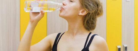 Una chica está bebiendo una botella de agua