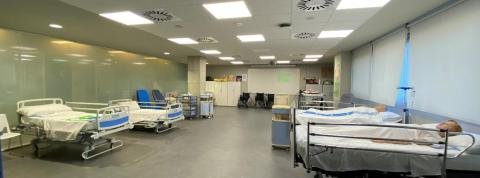 Sala de cuidados de enfermeria en un hospital con camas y personas tumbadas