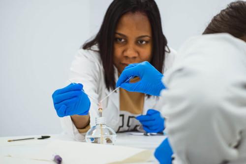 Estudiante de Química en el laboratorio mide líquidos con un tubo de ensayo.