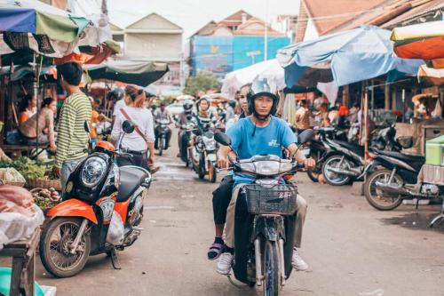 Una moto pasa por un mercado bullicioso en un país en vías de desarrollo económico.