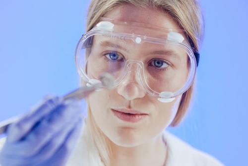 Una científica en laboratorio con guantes de protección y gafas de seguridad