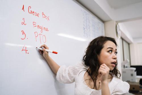 Maestra de educación infantil escribe en la pizarra.